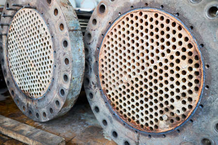 Corrosion, refinery heat exchanger chiller tubes with flange system. Two Industrial heat exchangers or boiler rusty tube sheet or tube board with deposits and corrosion at petrochemical enterpriseの写真素材