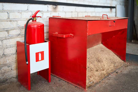 Primary means of fire extinguishing in case of fire or ignition, fire extinguishers and a firebox with sand in industrial enterprise production room.の写真素材