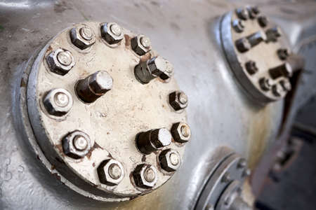 Two metal steampunk covers or hatches plate of compressor valves close up painted with gray paint bolted with studs and nuts background with copyspace.の写真素材