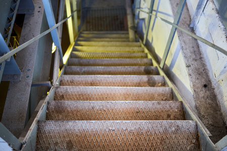 Example of chemical plant steampunk retro style interior part with copyspace. Abstract image of industrial textured rusted stairs going down vertical or downstairs.の写真素材