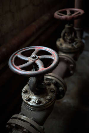 Industrial pair of valves ventil with flanges closeup selective focus over dark industrial steampunk background with copy space.の写真素材