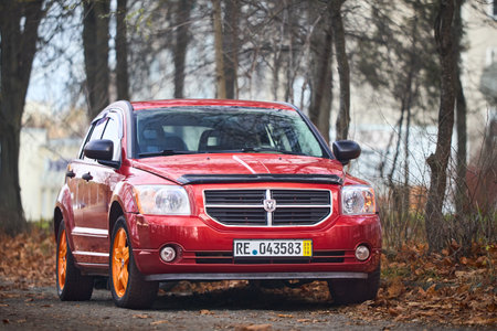 BERLIN, GERMANY - NOVEMBER 2021: Orange Dodge Caliber compact hatchback selective focus staying in autumn parking.のeditorial素材