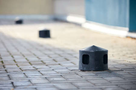 Air roof exhaust ventilation fan system of commercial building with hooded plastic chimneys flues and ducts in row on on tiled roof selective focus with copyspace.の写真素材