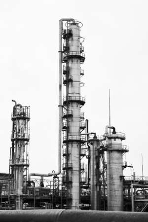 Old methanol distillation rectification refinery column towers and reactors under grey sky at chemical plant enterprise. Industrial black and white BW background vertical with copy space.の写真素材