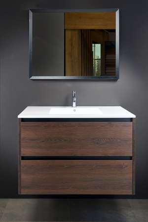 Stoneware countertop bathroom with tired beton wall stoneware tiled floor. Brown industrial flat loft bathroom with modern countertop basin, square mirror and wooden PVC cupboard.の写真素材