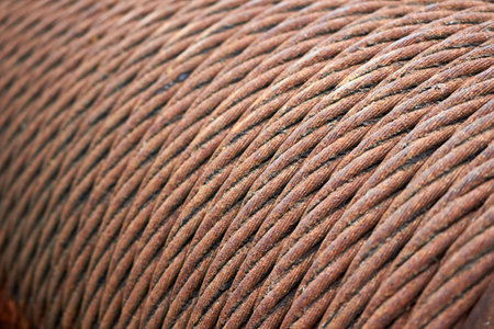 Steel cable sling hoist. Old obsolete rusty steel braided cable wounded on drum of industrial winch macro closeup texture background.の写真素材