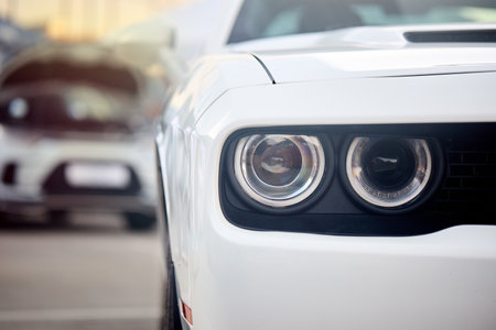 Berlin - August 2022: Dodge Challenger SRT Hellcat RED EYE WIDEBODY. Front view selective focus detailing with front headlight bumper and grill close up with out of focus background with sunflare.のeditorial素材