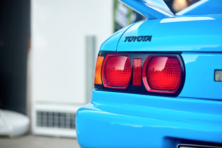 Berlin - August 2022: Toyota MR2 1993 logo badge emblem with back rearlight backlight or taillight of black metallic car shot closeup selective focus on out of focus background with copyspace.のeditorial素材