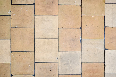 Orange brown purple old shabby worn out floor tiles with damages cracks dirt caverns potholes and paint stains. Art design background texture.の写真素材