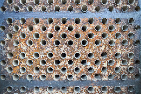 Tube sheet plate of heat exchanger or boiler closeup texture macro industrial background with insoluble hard mineral deposits salts scale welding seams and corrosion. Trypophobia concept.の写真素材