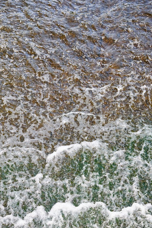 Foamed water top view with bubbles. Water foam abstract background texture. Waves surface closeup.の写真素材