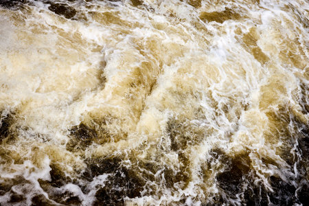 Wake brown water bubbling behind ship with bubbles and splashes background texture.の写真素材