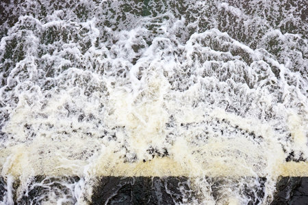 Foamed water top view with bubbles. Water foam waterfall threshold abstract background texture. Waves surface closeup.の写真素材