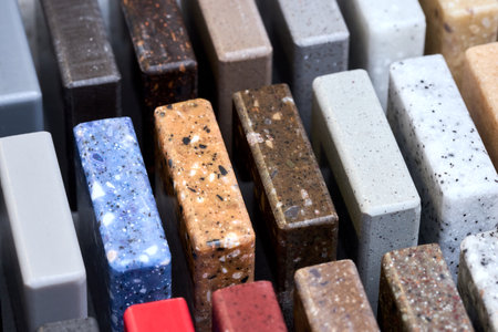 Porcelain multicolored stoneware square samples as kitchen countertop examples of future kitchen fasade exterior. Samples slabs of natural granite marble quartz for stone countertops close up.の写真素材