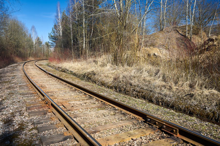 Railway track in the spring forest with blue sky with railway drainage system rail construction. Rail trackside drainage. Drainage channels of railway.の写真素材