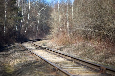 Railway track selective focus in the spring forest with blue sky with railway drainage system rail construction. Rail trackside drainage. Drainage channels of railway.の写真素材
