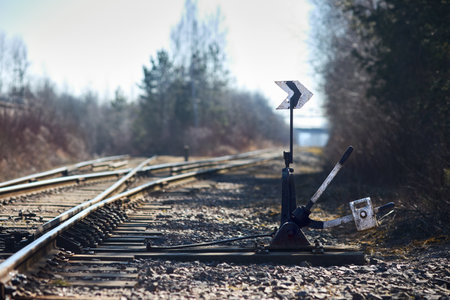 Hand-operated railroad switch with lever signal weight. Old railroad switch near spring sunny forest. Selective focus shot.の写真素材