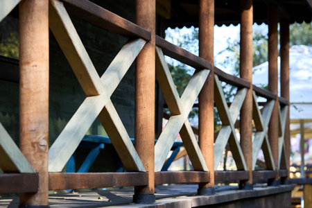 Terrace or veranda wooden fence railing. Decorative element. Wooden details of country house architecture exterior selective focus.の写真素材