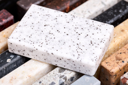Porcelain and stoneware artificial stone square sample laid on kitchen countertop examples of future kitchen fasade exterior. Samples slabs of natural granite marble quartz for stone countertops.の写真素材