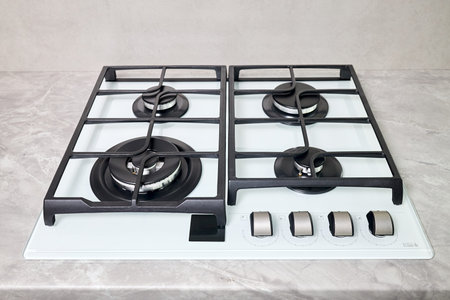 Modern hob gas stove made of tempered white glass using natural gas or propane for cooking products...