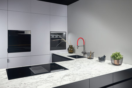 Upscale modern flat design loft kitchen with Induction cooker black glass hob with integrated hood...