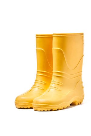 Pair of yellow rubber boots for kids isolated on white background three quarter view.の写真素材