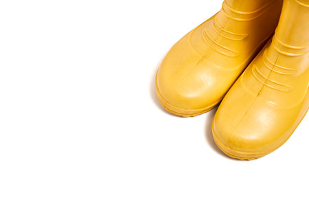 Pair of yellow rubber boots for kids isolated on white background three quarter view with copyspace.の写真素材