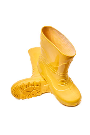 Pair of yellow rubber boots for kids isolated on white background three quarter view one over another sole side.の写真素材