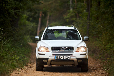 Berlin, Germany - October 3, 2023: Volvo XC90 4.4 v8 1st generation restyling 4WD SUV test drive in fall country road on forest background front view.のeditorial素材