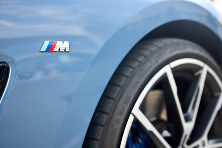 Berlin, Germany - August 20, 2022: BMW 8 Series G16 Gran Coupe 840d xDrive M-package. Car detail m-pack badge logo emblem selective focus closeup with alloy wheel tire out of focus background.のeditorial素材