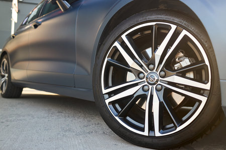 Berlin, Germany - August 20, 2022: third generation Volvo S60 detail shot. Volvo badges logo emblem on wheel plug and Kormoran Uhp 235 40 R19 96Y wheel selective focus close up.のeditorial素材
