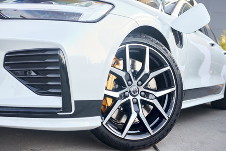 Berlin, Germany - August 20, 2022: 3rd generation Volvo V60 T8 PoleStar AND Electric hybrid detail shot. Volvo emblem on alloy wheel plug Brembo brake caliper Continental tire opened charging socket.のeditorial素材