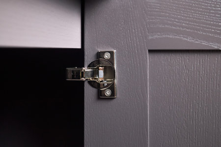 Hinge cabinet of kitchen moss grey cupboard door metal furniture isolated under ash wood countertop tabletop, hardware on wood with copyspace.の写真素材