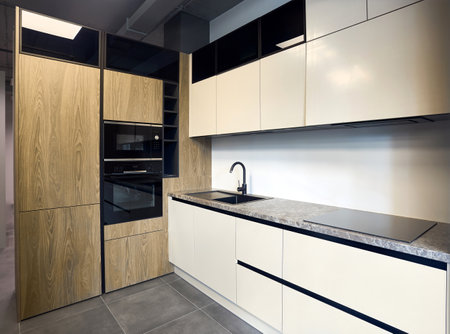 Urban rustic loft style kitchen interior in wooden facade and stoneware countertop tabletop with built-in appliances as induction stove hob cooker sink microwave oven and oven fridge dishwasherの写真素材