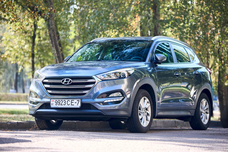 Minsk, Belarus - September, 18 2024: Hyundai Tucson Premium 3rd generation pre-facelift SUV 2015 2021 blue metallic front three quarter view parked in simmer street with foliage backgroundのeditorial素材