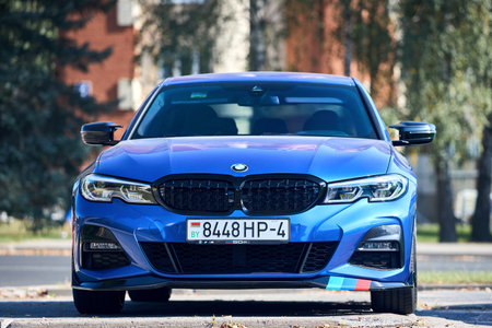 Minsk, Belarus - September, 18 2024: metallic blue BMW 3 Series Sedan Seventh generation, G20 2019-present, manufactured and marketed by BMW parked over urban background.のeditorial素材