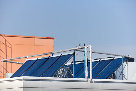 Solar water heating system on rooftops. Solar installation for generation of green electricity and water heating on the roof of industrial building boiler house.の写真素材