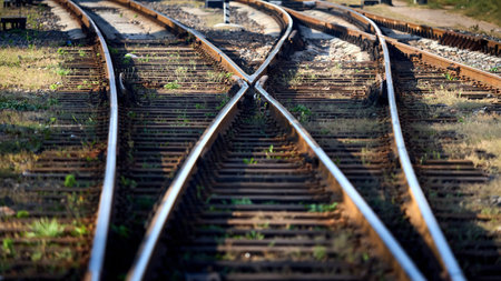 Large empty railroad crossing without fork. Concept of industrial logistic and transportation background with selective focus on intersection with copy space 16x9.の写真素材