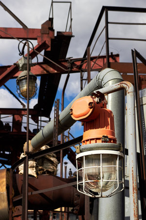 Lighting mast with lantern in explosion-proof and fire-proof design close-up over background of pipelines buildings and equipment of chemical plant with copy spaceの写真素材