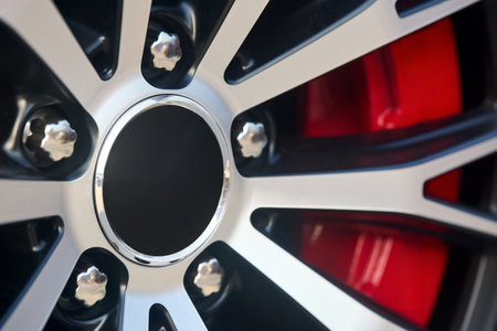 Alloy wheel plug with red brake calipers and rims selective focus closeup car detailingの写真素材