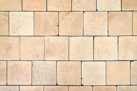 Orange brown white beige old shabby worn out floor tiles with damages cracks dirt caverns potholes and paint stains. Art retro grunge design background texture.の写真素材