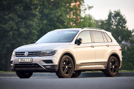 Minsk, Belarus - May, 28 2023: Volkswagen Tiguan II compact 4motion crossover car SUV manufactured by Volkswagen 2016 to present, frontside view parked in street over green foliage background.のeditorial素材