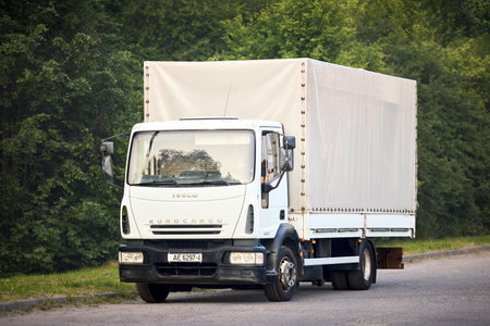 Minsk, Belarus - May, 28 2023: Iveco EuroCargo 120E21 Second generation 2002-2015 medium duty truck produced by Italian manufacturer Iveco. White truck parked in street over green foliage background.のeditorial素材