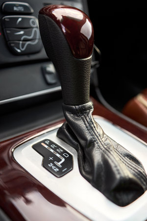 Automatic transmission shift selector lever. Close up manual shift of modern car gear shifter. 4x4 gear shift. SUV Modern Car vehicle detailing selective focus shot.の写真素材