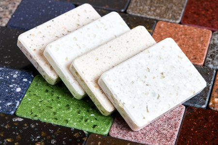 Porcelain stoneware artificial stone square samples as kitchen countertop examples of future kitchen fasade exterior. Samples slabs of natural granite marble quartz for stone countertops close up.の写真素材