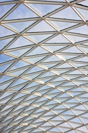 Glass roof of the mall inside view with part of white concrete wall and lightning protection system outside. Vertical shotの写真素材
