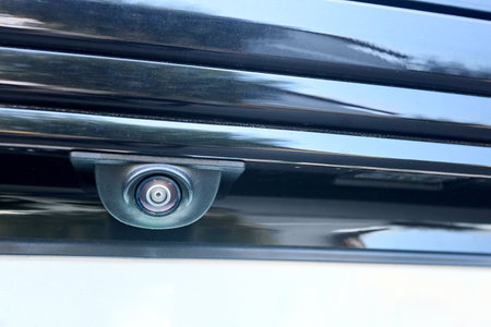 Car rear view camera parking sensor accessory reverse back new vehicle spycam with waterdrops. Luxury car rear view camera close up for parking assistance. Concept of safety car driving while parkingの写真素材