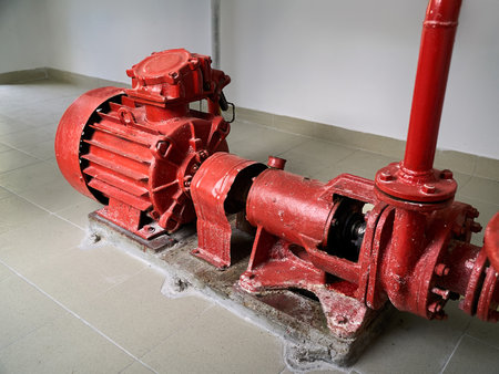 Industrial fire fighting centrifugal pump of fire extinguishing system for fire fighting water monitors and sprinklers system of petrochemical plant, red colored with valves pipelines and water heater.の写真素材