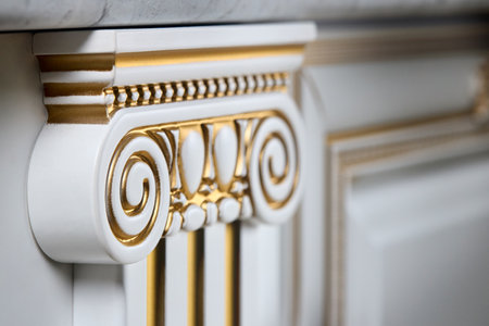 Selective focus fragment of beige wooden cabinetry kitchen carved detail. Carved decorative detail. Wooden pilasters. Decor furniture. Carved decor elements. Decorative elements.の写真素材