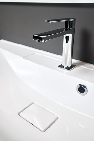 Interior detail of bathroom with luxury square design washbasin sink with square drain and faucet. Bathroom interior sink with gray tiled wall and mirror modern flat minimalistic design.の写真素材